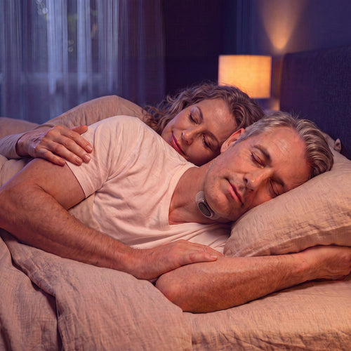 Couple sleeping peacefully while wearing the RestWell